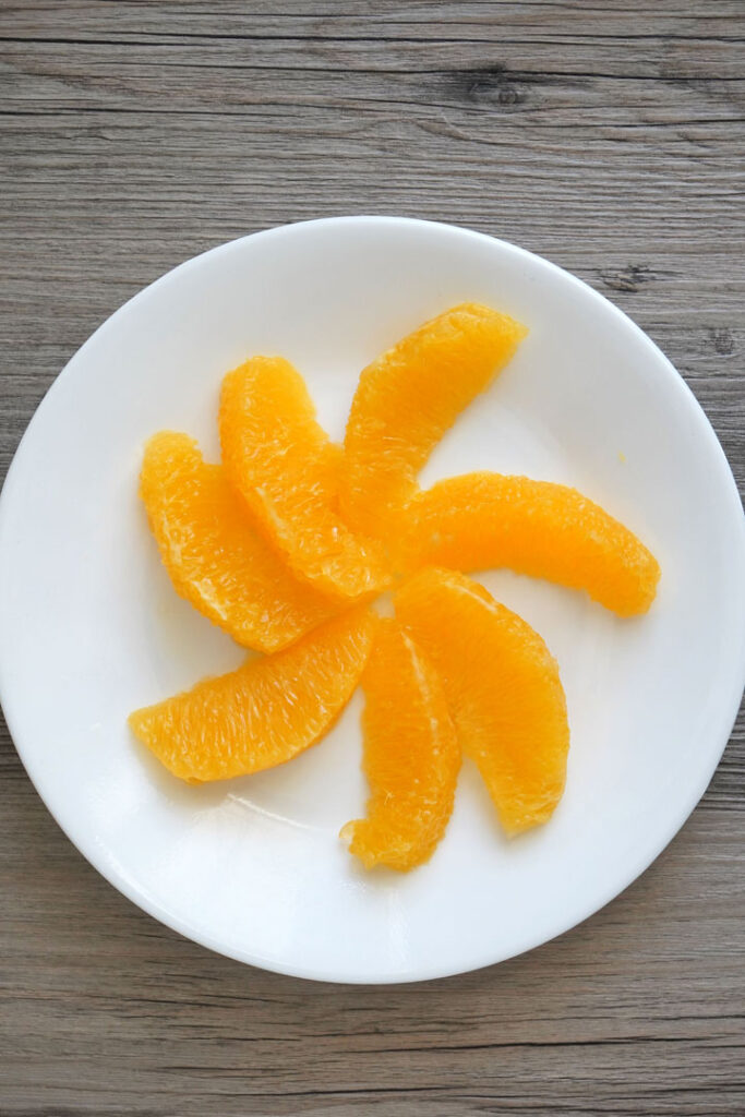 Segemented orange slices on a white plate.