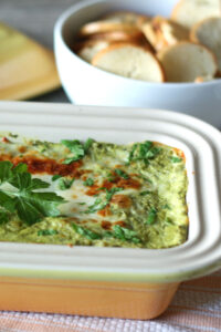 spinach artichoke dip in yellow casserole dish