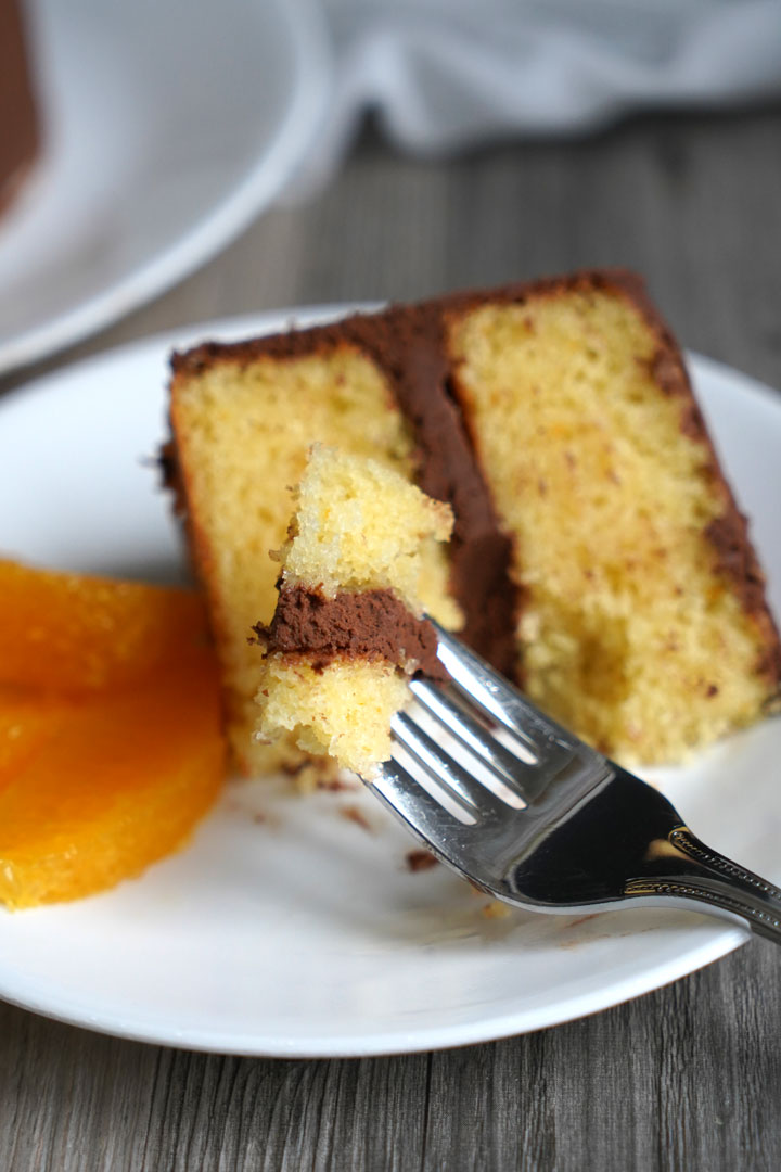 Piece of cake on a fork with slice in the background.