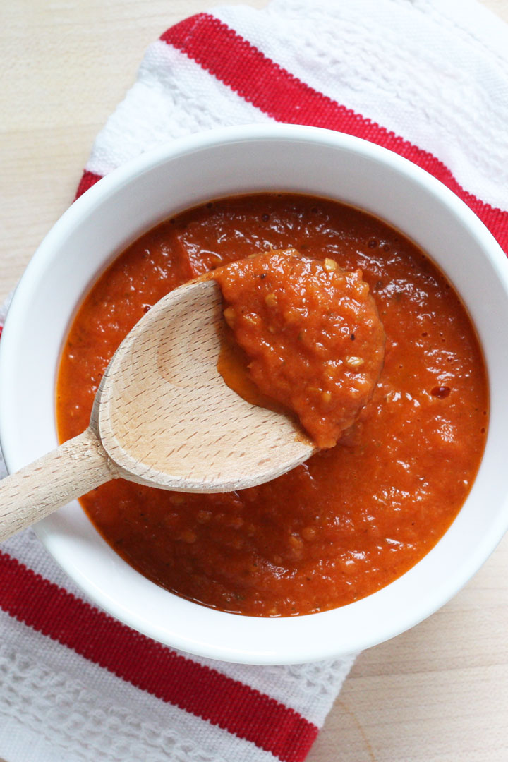 Pizza sauce on a wooden spoon.