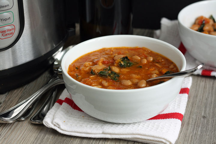 A bowl of cannellini bean soup on red and white napkin.