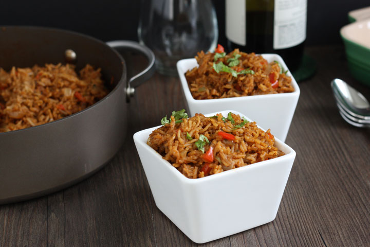 Rice in white bowls next to pot.