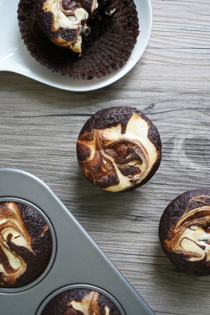 Top view of black bottom cupcakes showing swirled batters. 