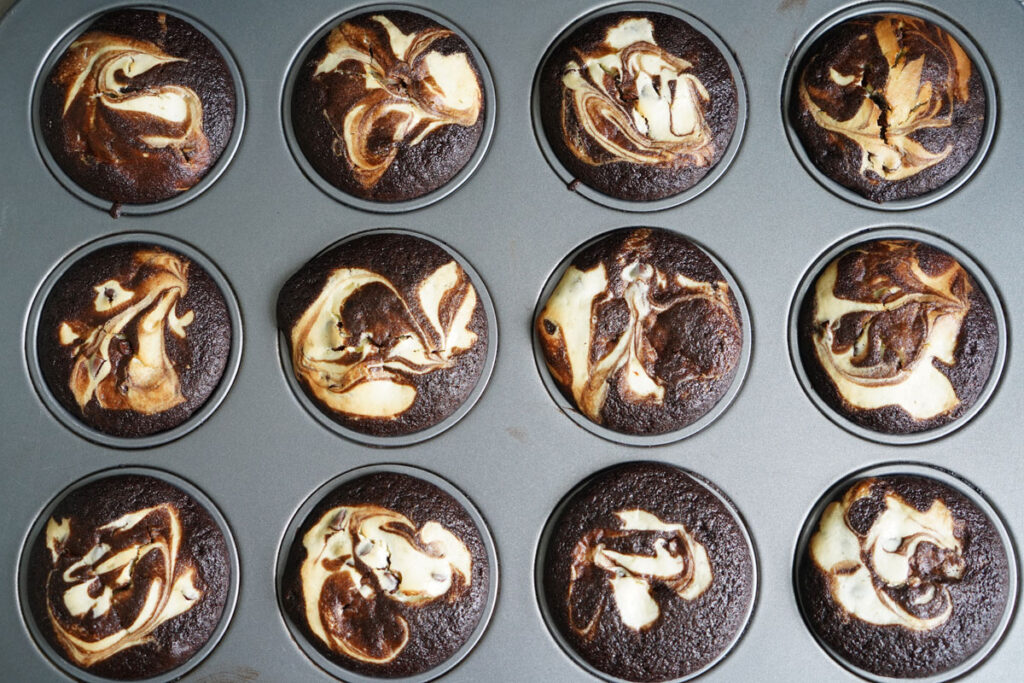 12 cup muffin tin with baked black bottom cupcakes.