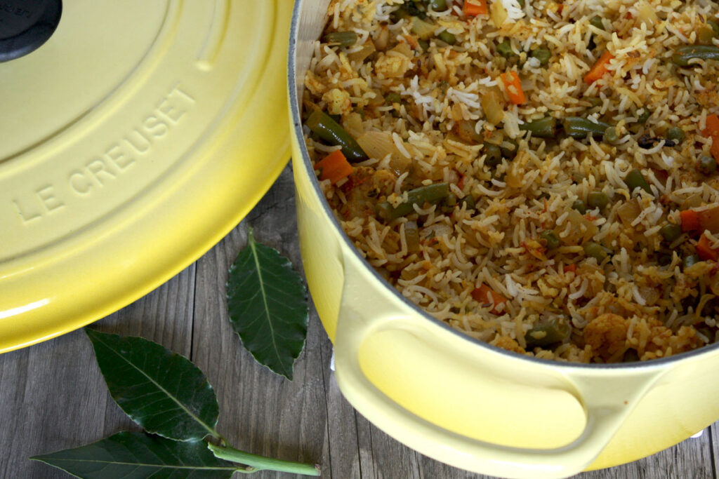 Biryani in a large yellow cast iron pot, top view.