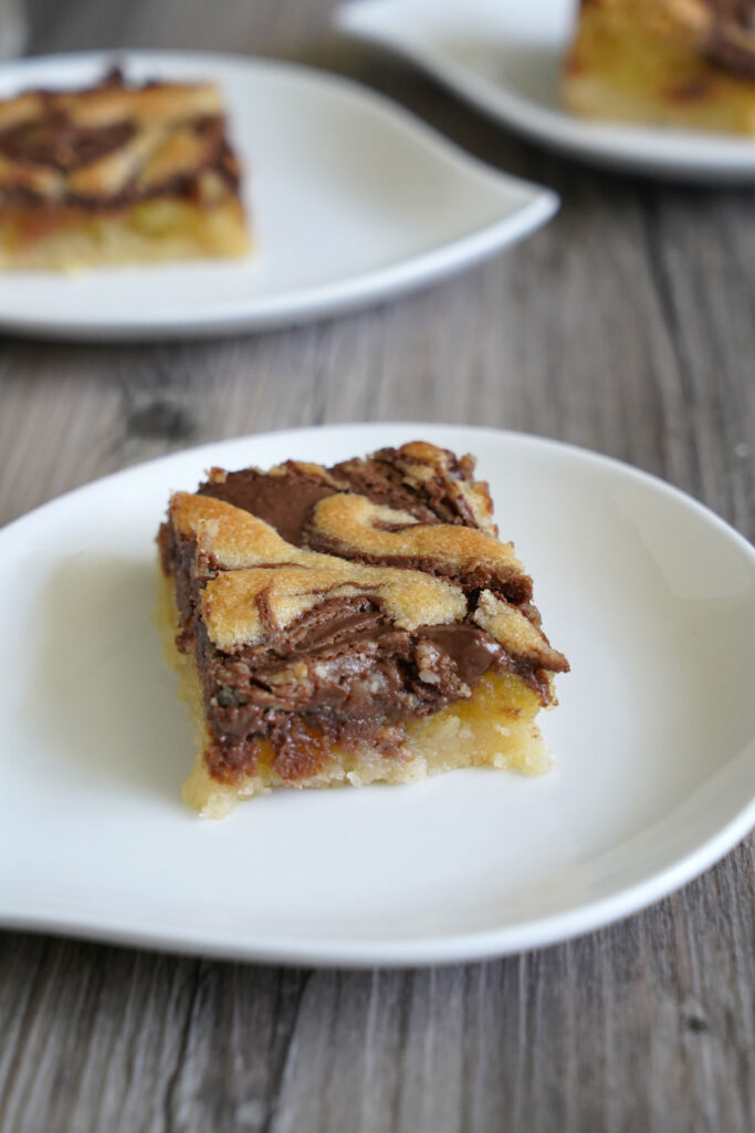 Single Nutella frangipane bar on white plate with close up view of swirled design.