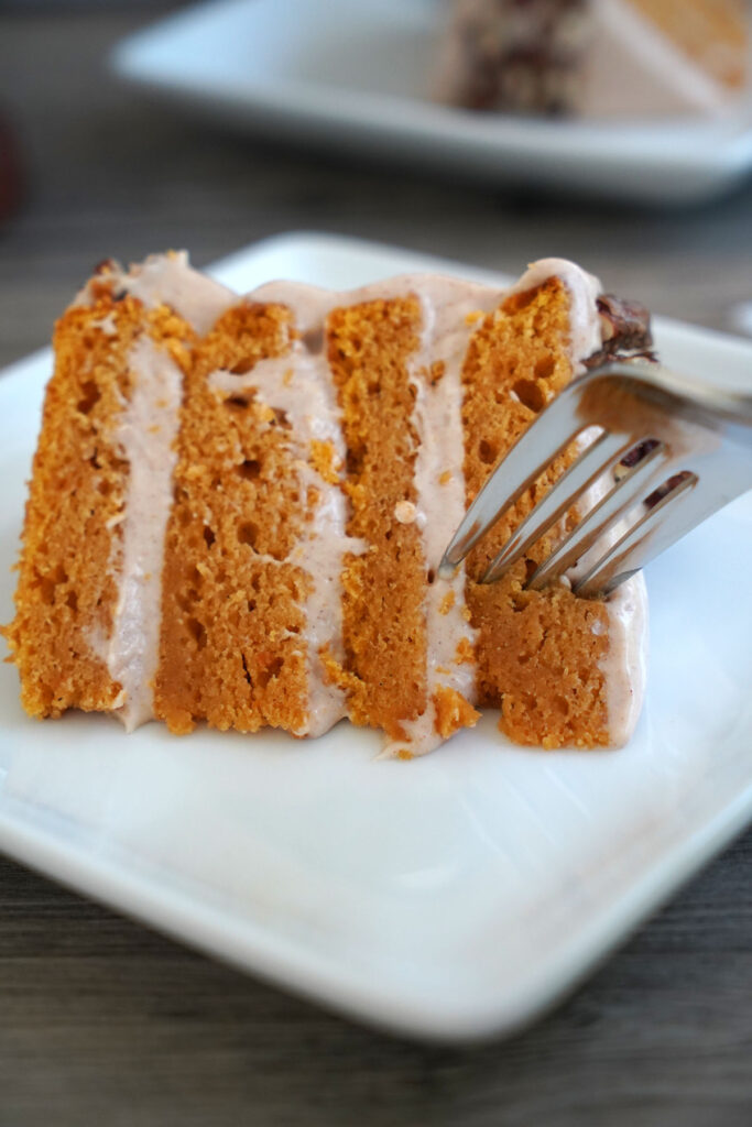 Fork being inserted into a slice of cake.