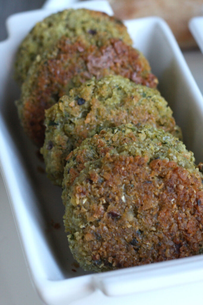 Baked falafel patties in white tray.