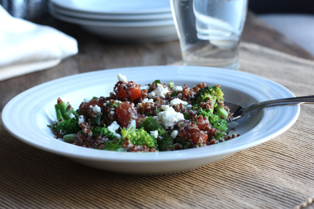 Lemon quinoa salad in a white plate with a fork.