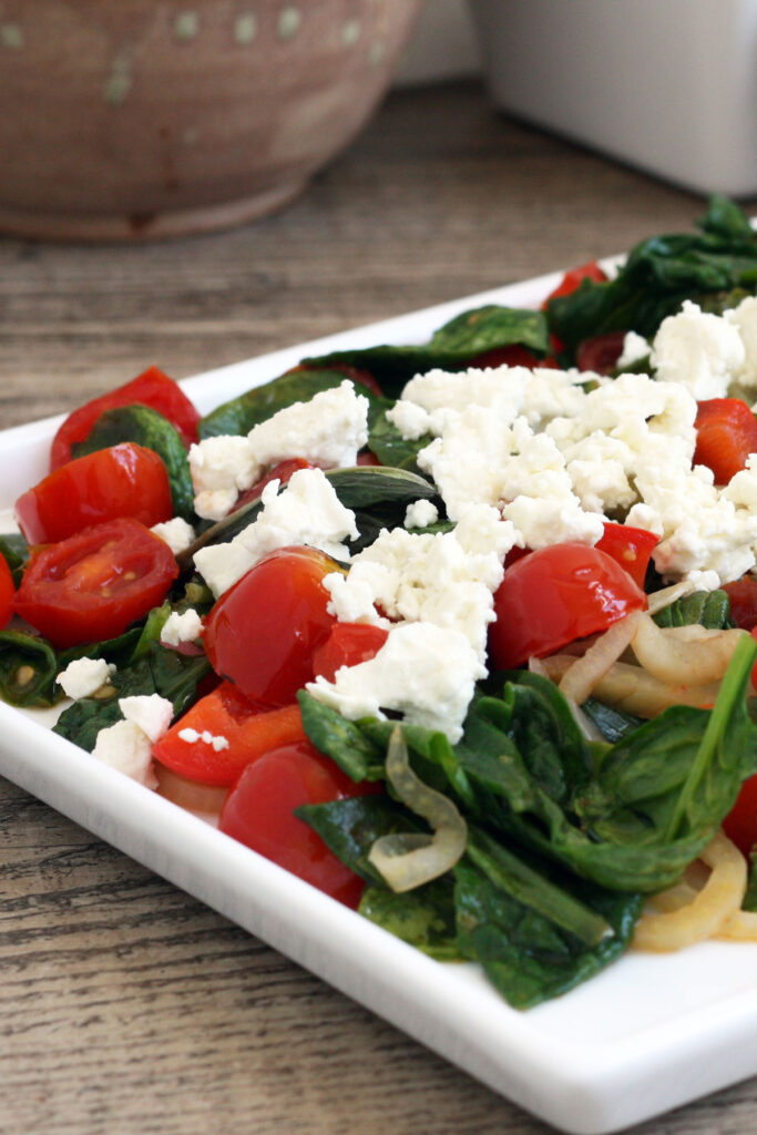 Close up view of warm spinach salad.