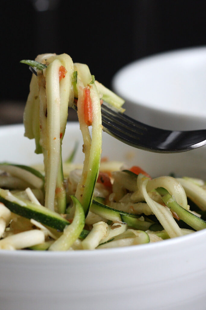 Zucchini salad ribbons on a fork.