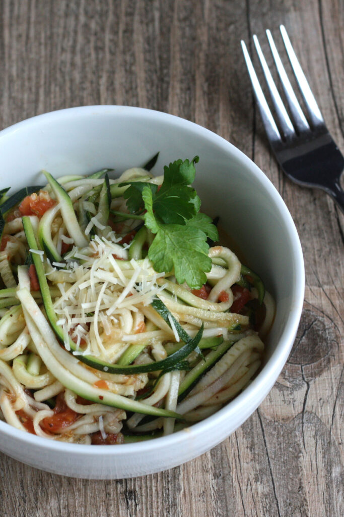 Zucchini salad in white bowl.