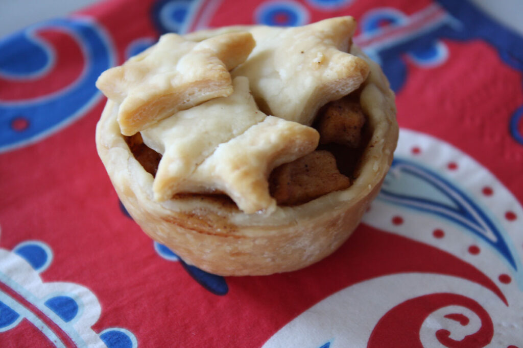 One mini apple pie on a napkin.