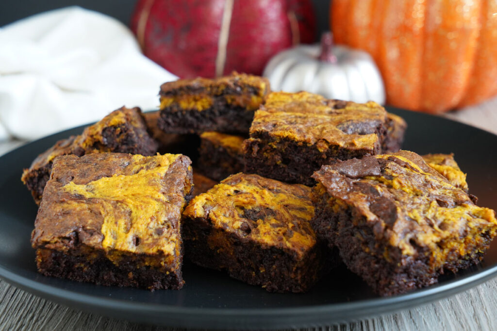 Pumpkin brookies on a black platter with pumpkins in the background.