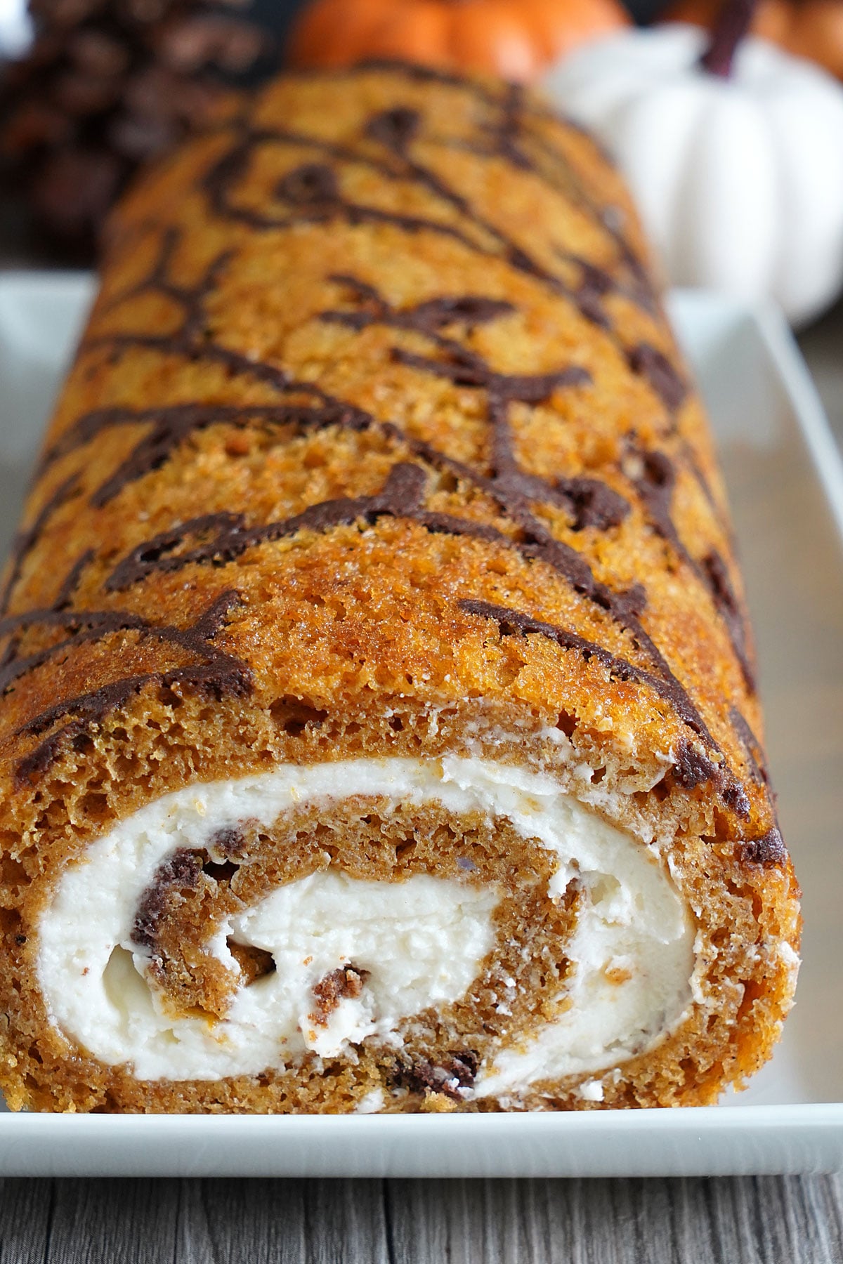 Close up of decorated pumpkin roll showing off swirl.