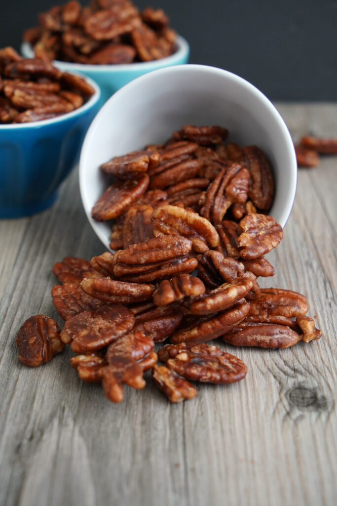 Candied pecans spilled out of a small bowl.