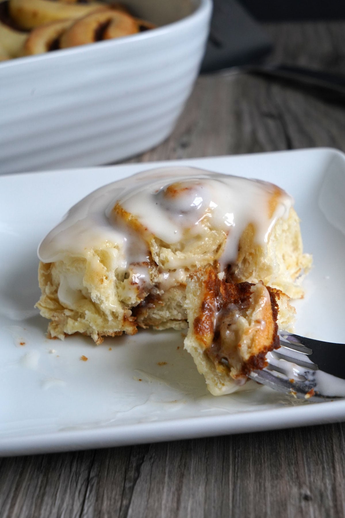 Bite of pumpkin spice cinnamon roll on a fork.