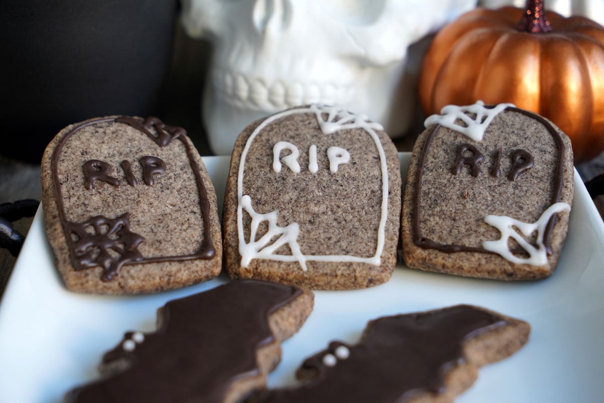 Speckled Oreo tombstone cookies piped with RIP and spider webs in black and white icing.