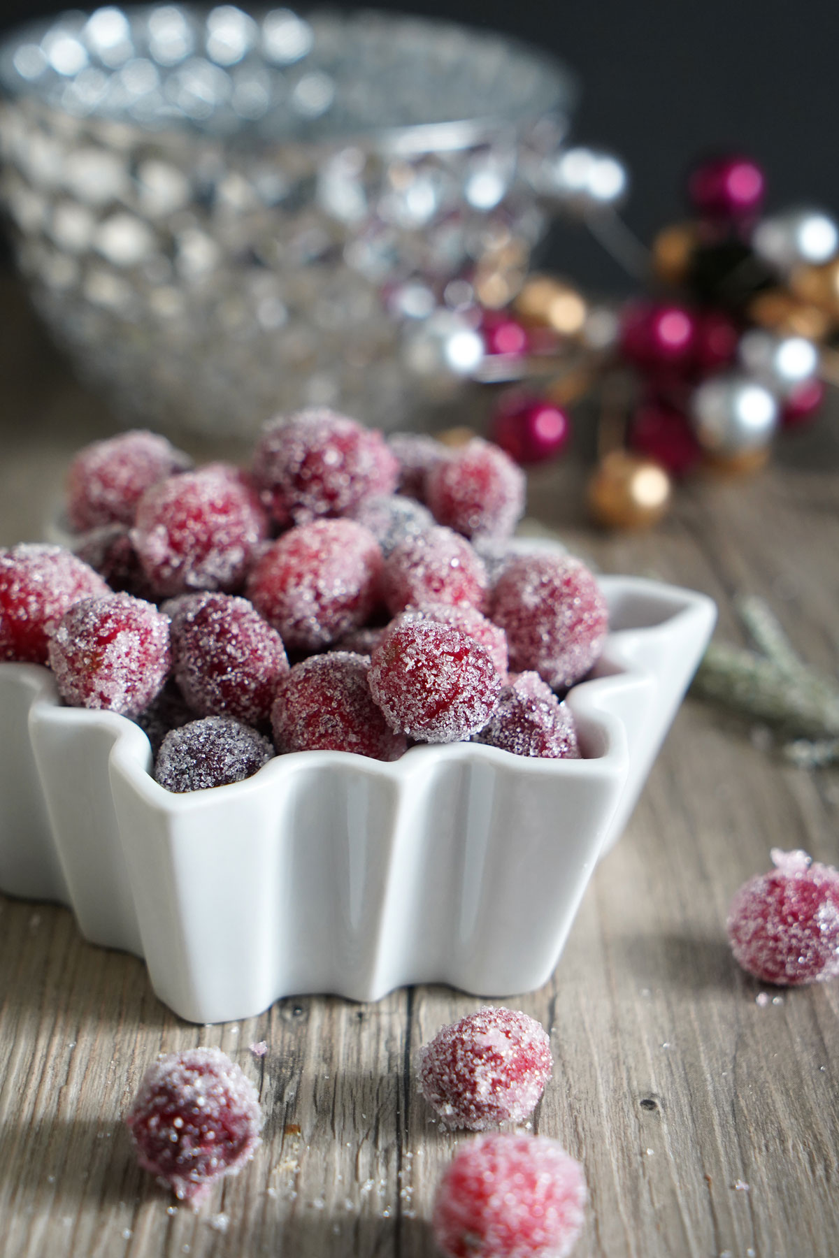 Sugared cranberries in a white bowl.