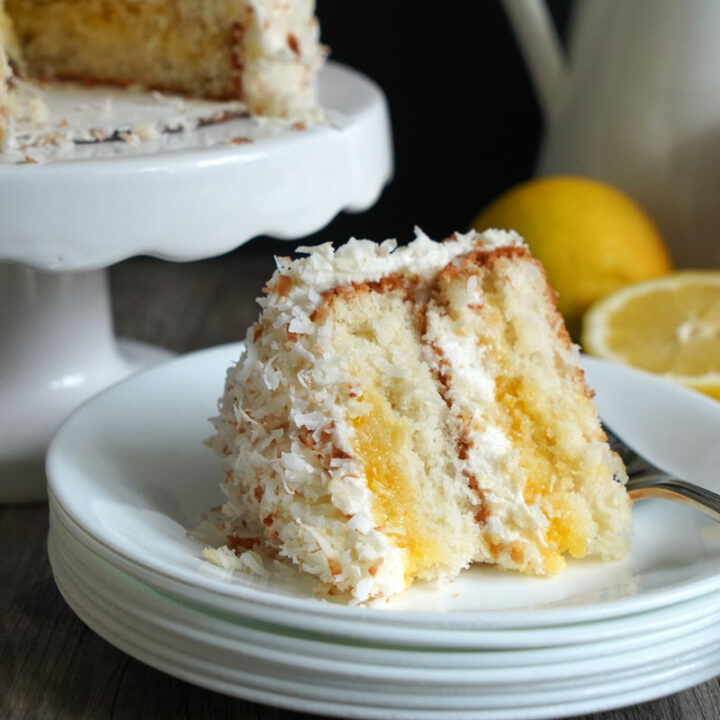 Slice of lemon coconut cake on white plate.