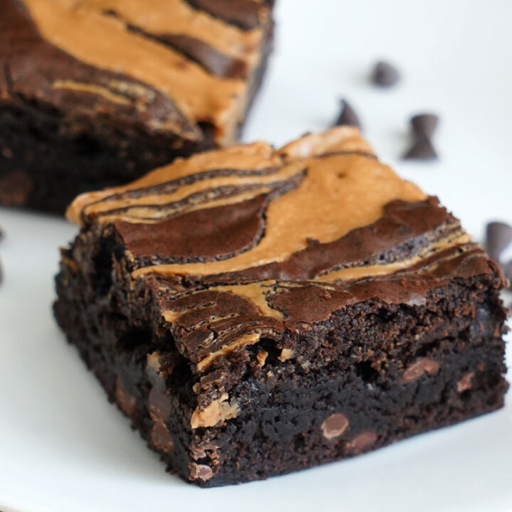 Closeup of peanut butter brownie slices on white plate.