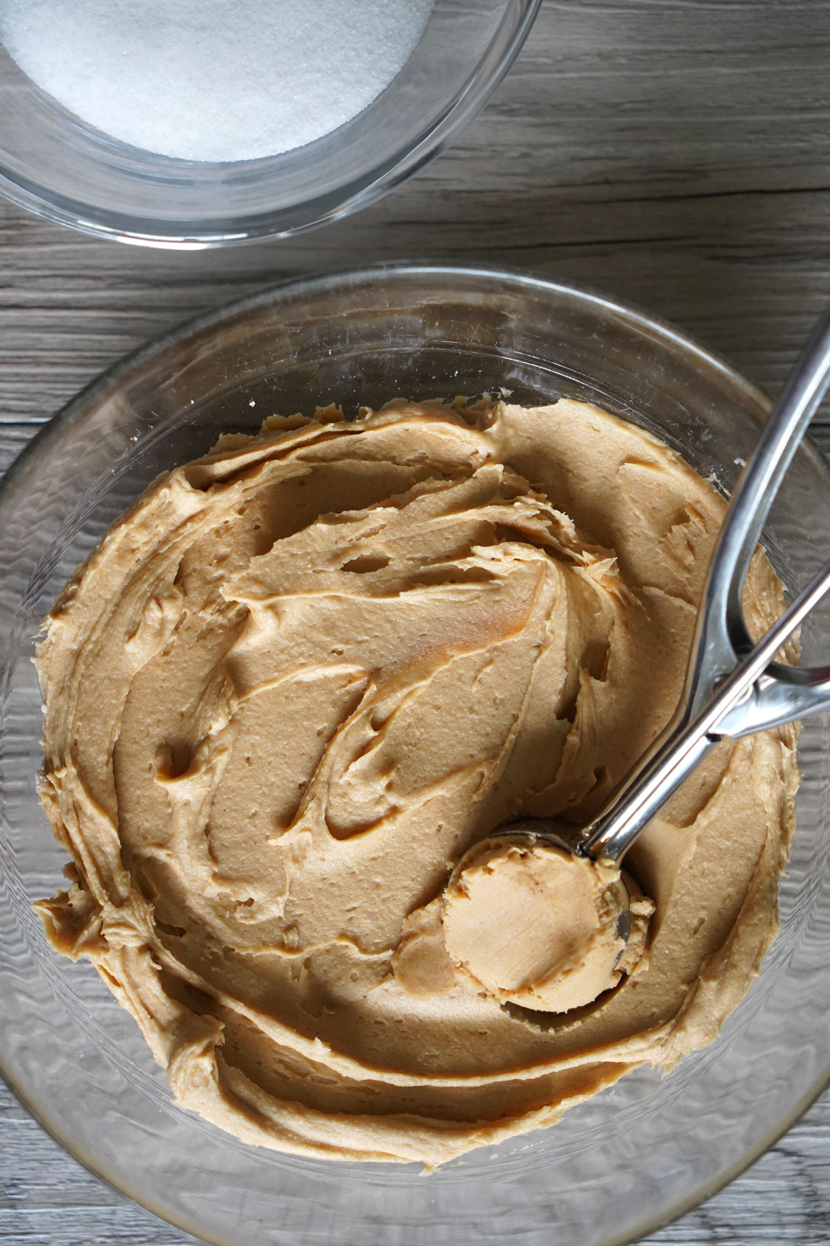 Peanut butter cookie dough being scooped with cookie scoop.