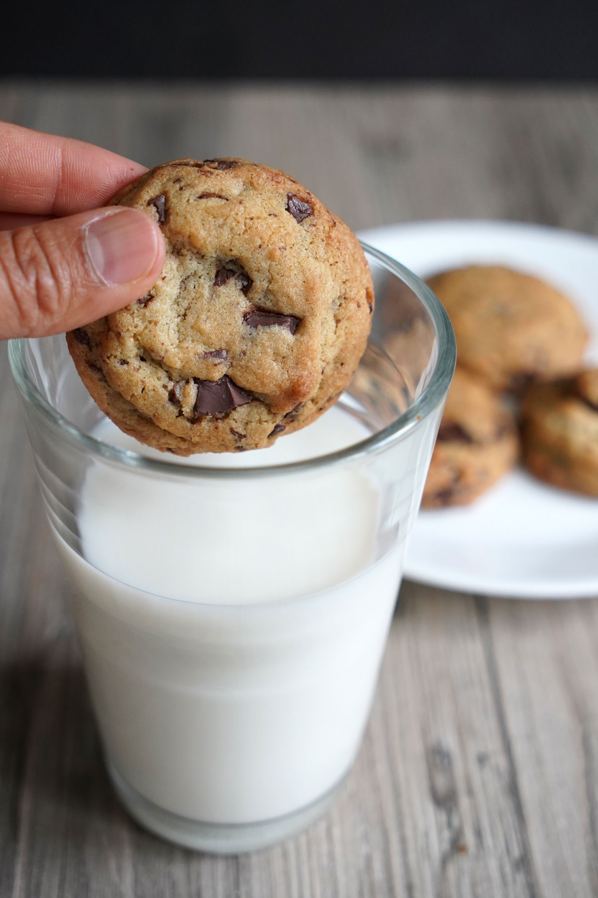 Cookie being dipped in a glass of milk.