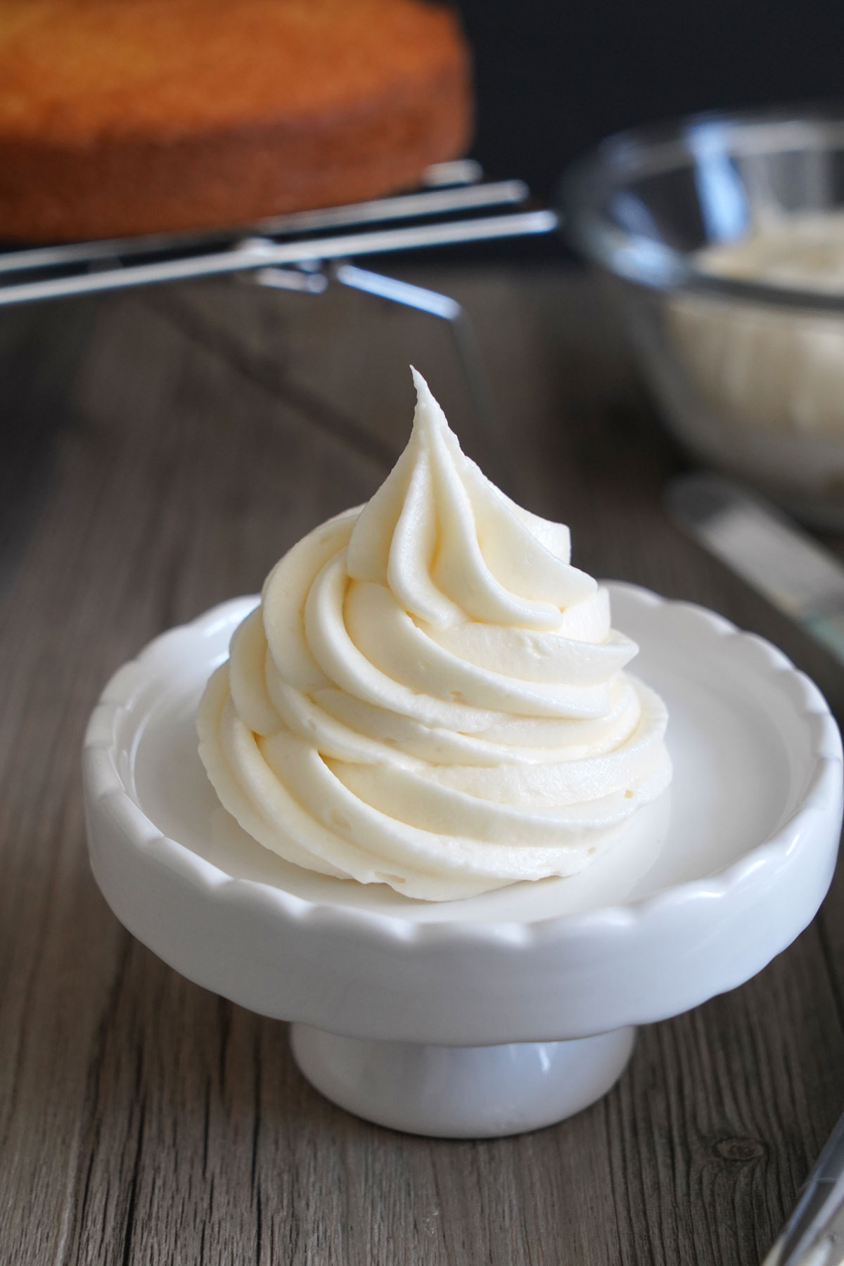 Cream cheese frosting swirled onto mini cake stand.