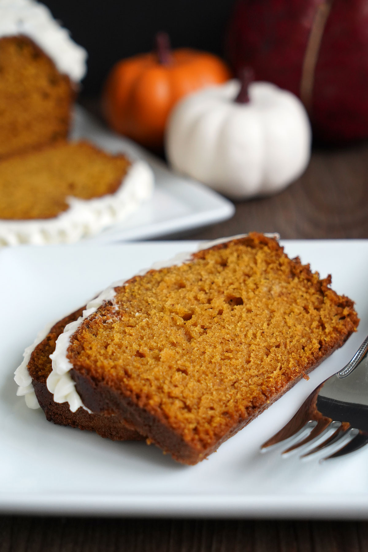 Two slices of pumpkin bread on white plate.