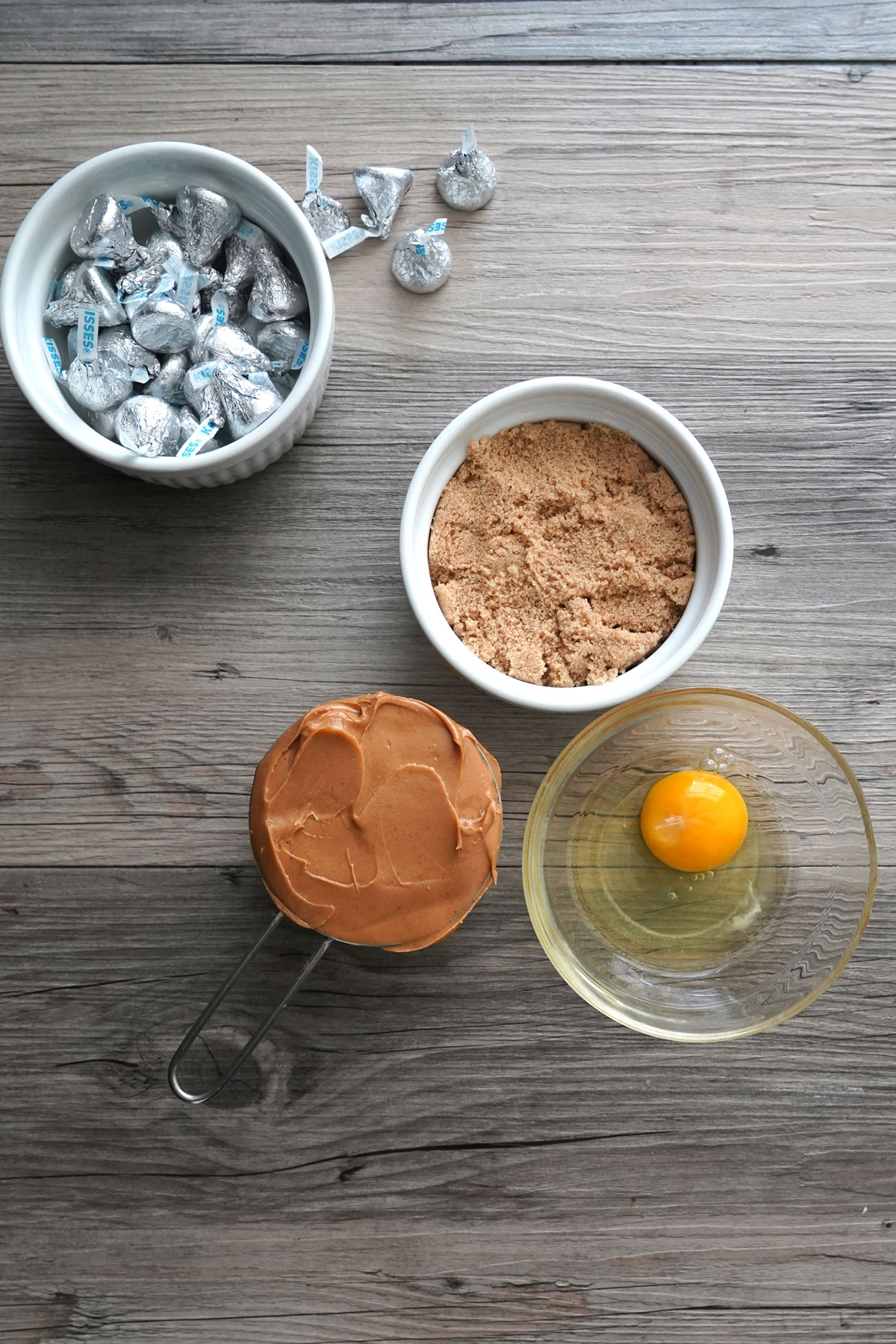 Ingredients for peanut butter blossom cookies: chocolate kisses brown sugar, peanut butter and egg.