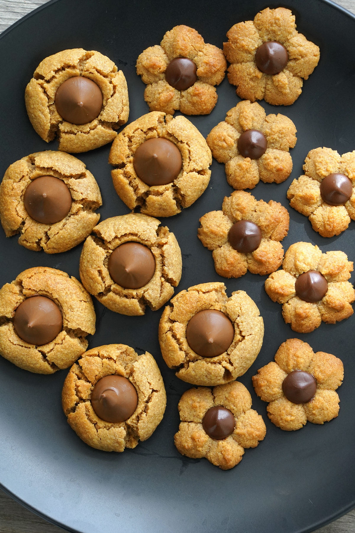 Peanut butter blossom cookies on a black dish. Overhead shot.