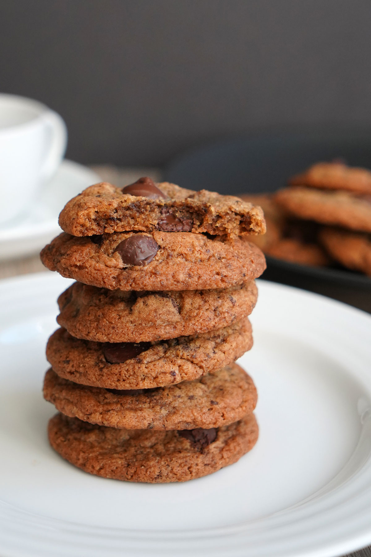 Stack of espresso chocolate chip cookies on white plate.