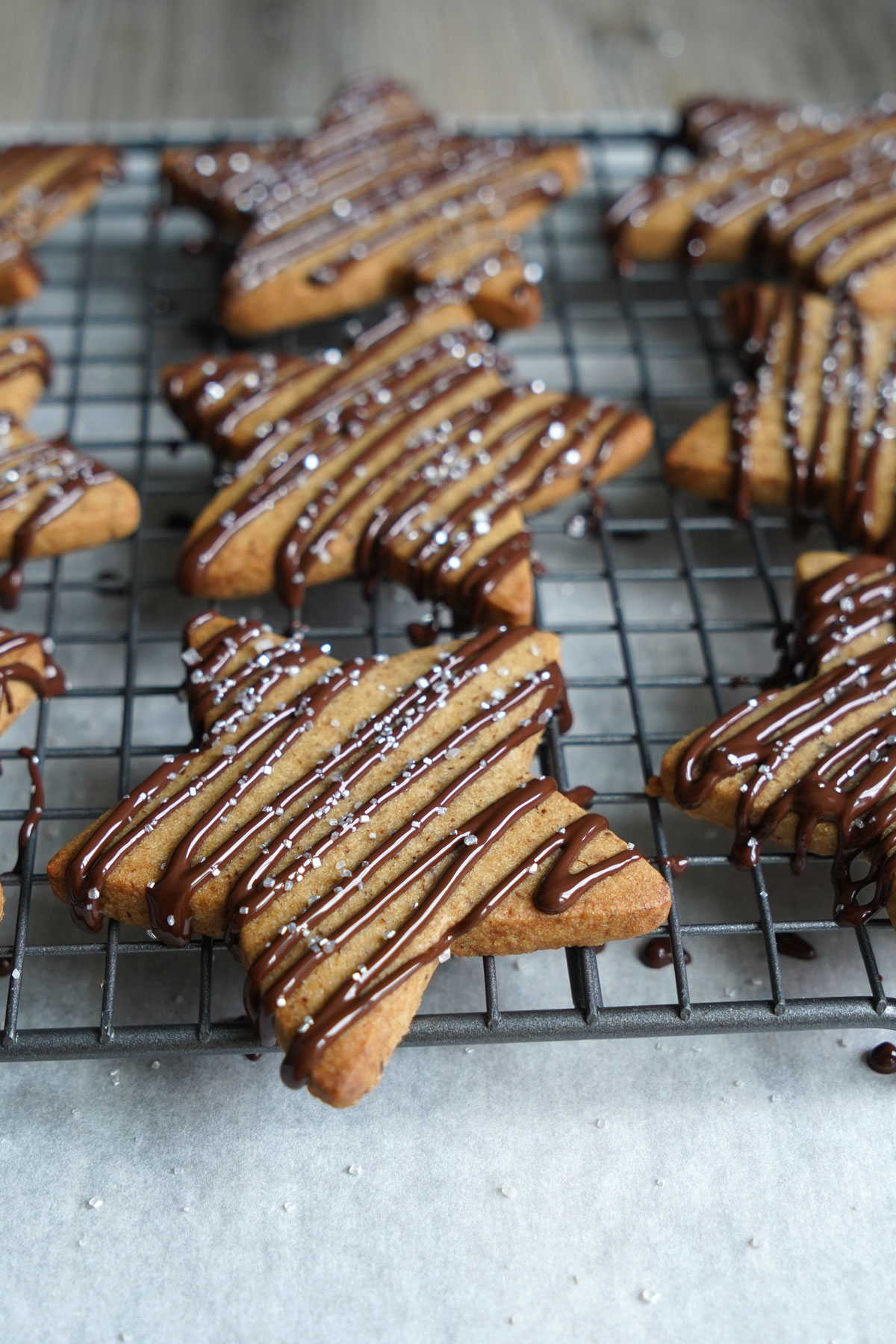 Star shaped sugar cookies with chocolate drizzle, drying on a cooling rack. Close up view. 