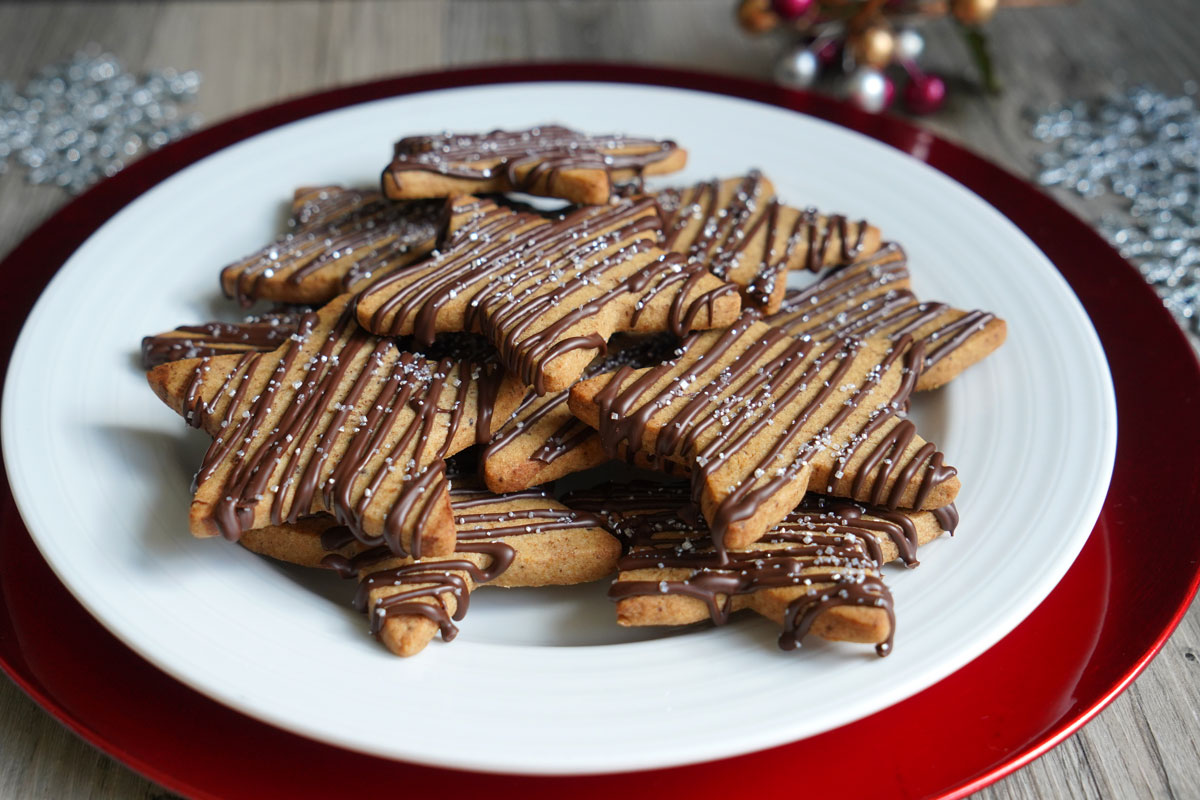 Star shaped sugar cookies with chocolate drizzle on a white plattter. 