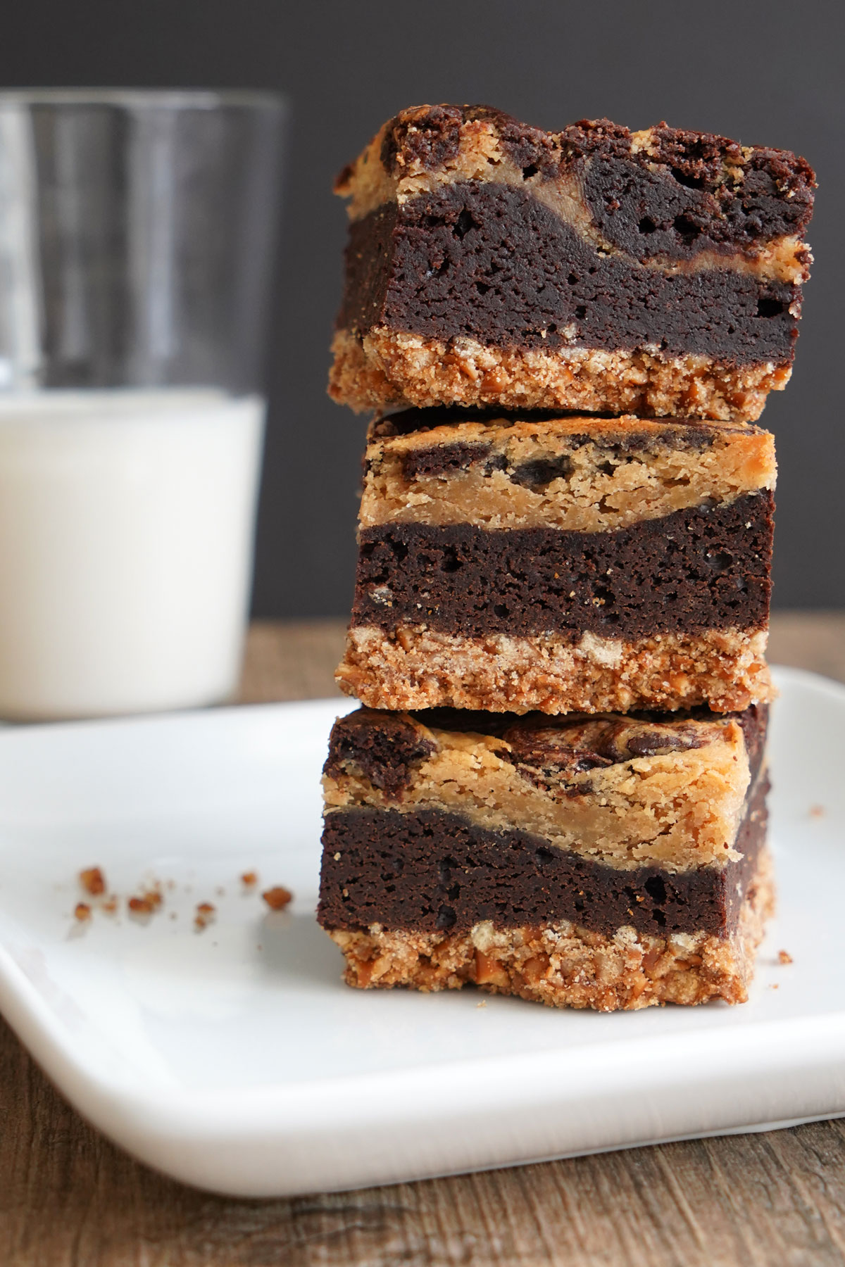 Stack of three pretzel crust peanut butter cheesecake brownies.