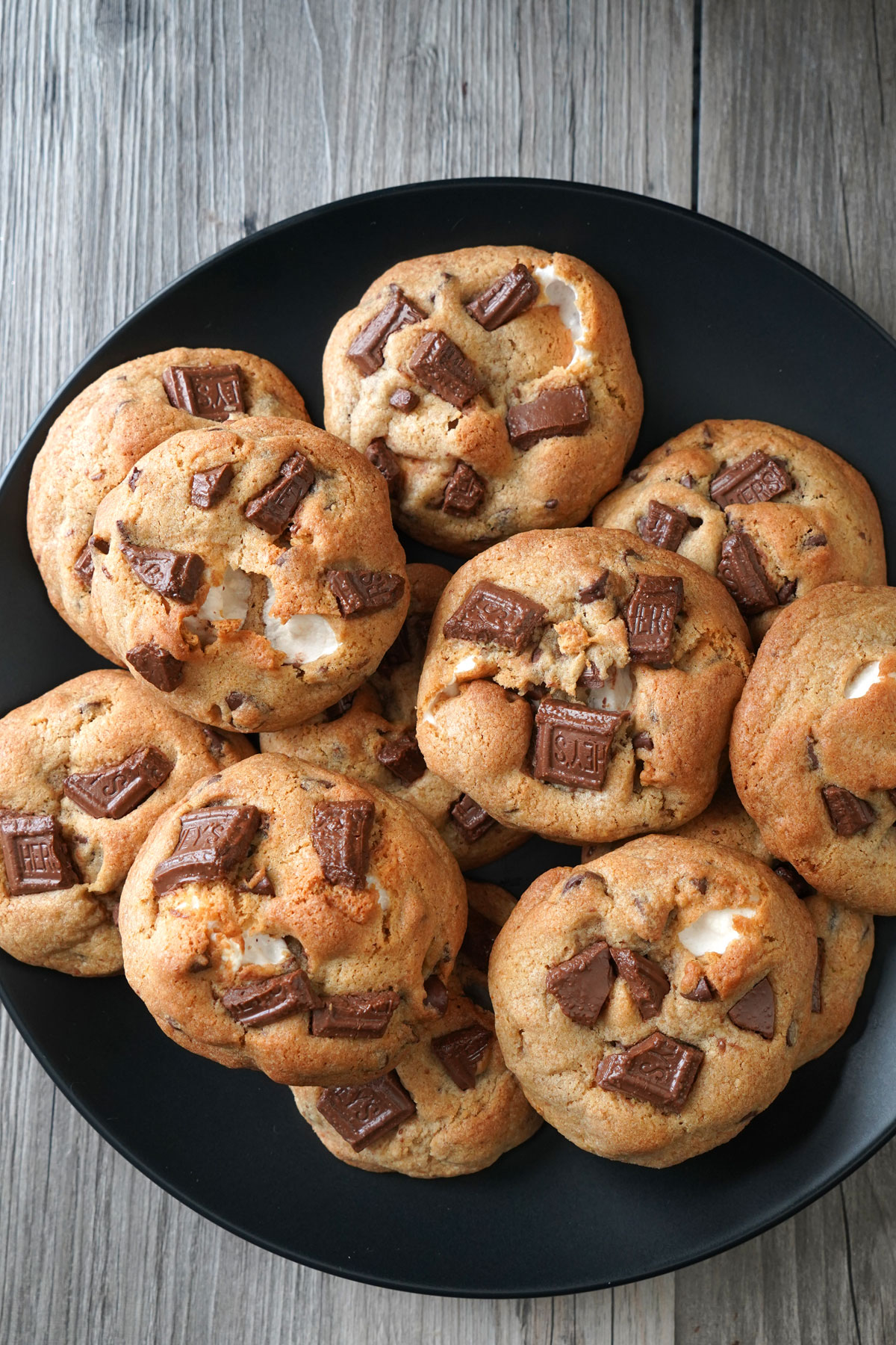 S'mores stuffed cookies on a black plate.