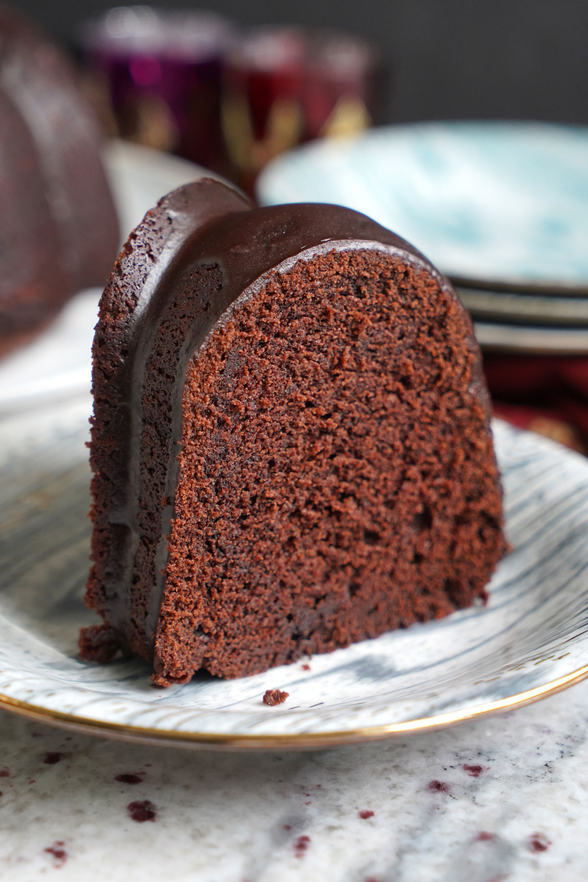 Slice of red wine bundt cake on plate.