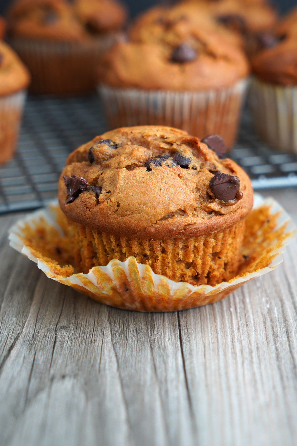 Close up of pumpkin muffin with paper liner peeled off.