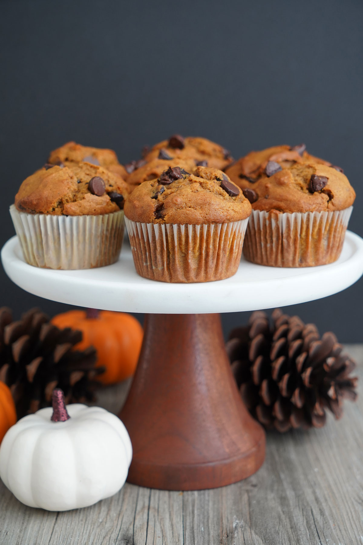Pumpkin muffins on white cake stand.