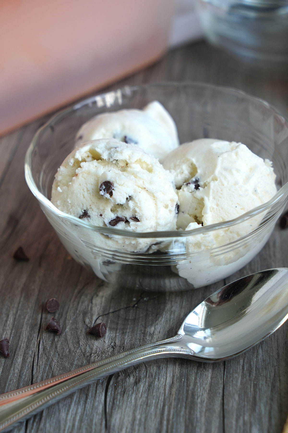 Three scoops of chocolate chip ice cream in a clear bowl.