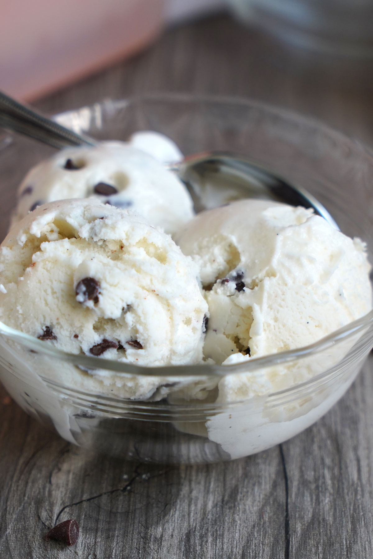 Three scoops of ice cream in a bowl with spoon.