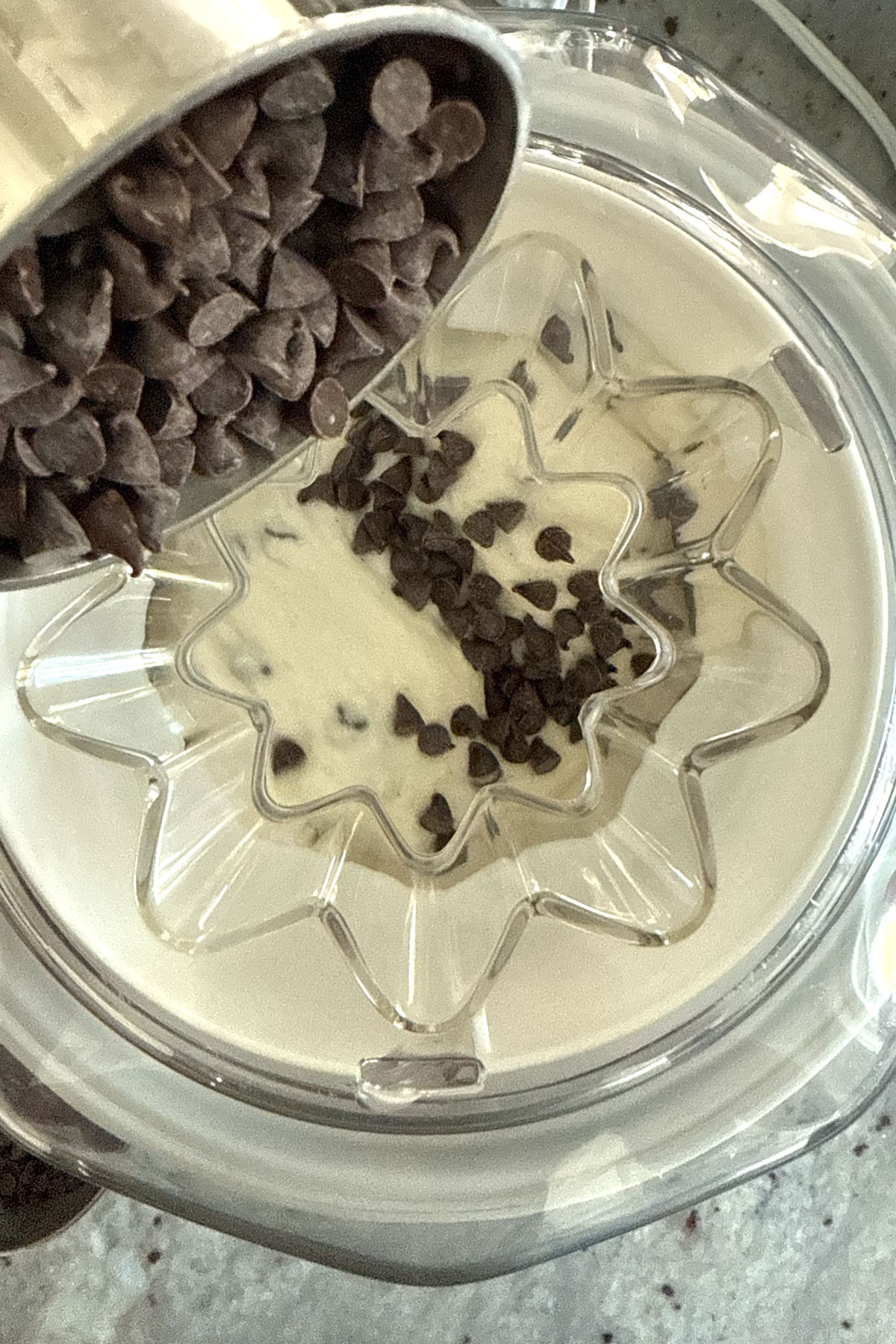 Chocolate Chips being added to the churning ice cream.