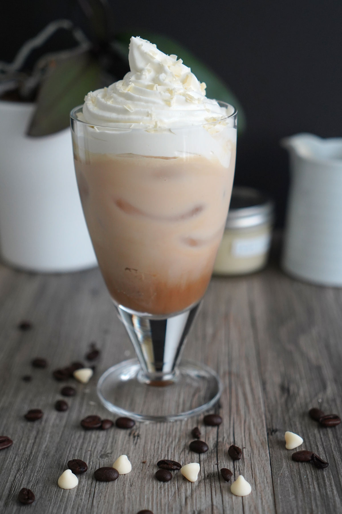 Iced White Chocolate Mocha Drink, topped with whipped cream and white chocolate shavings in a tall glass