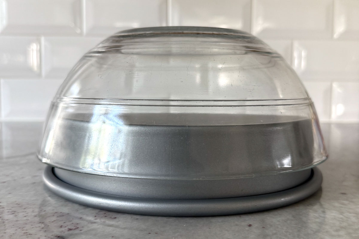 Empty bowl turned upside down on top of empty upside down cake pan to show the right sizing for pan and bowl.