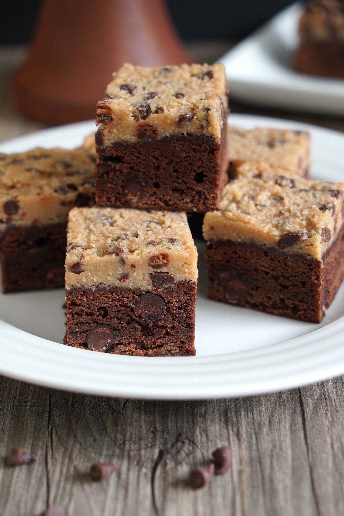 Slices of cookie dough brownies arranged on a white plate, showing the distinct layers of brownie and cookie dough.