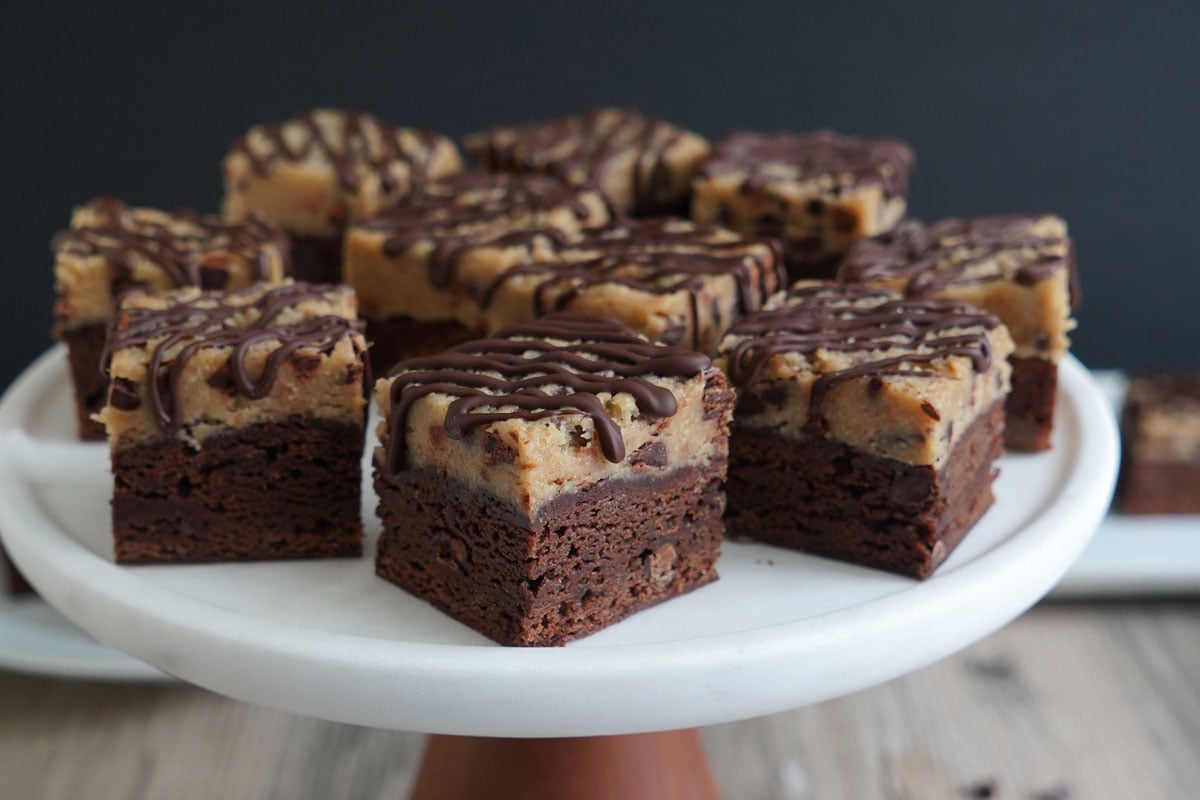 Cookie dough brownies on cake pedestal. 
