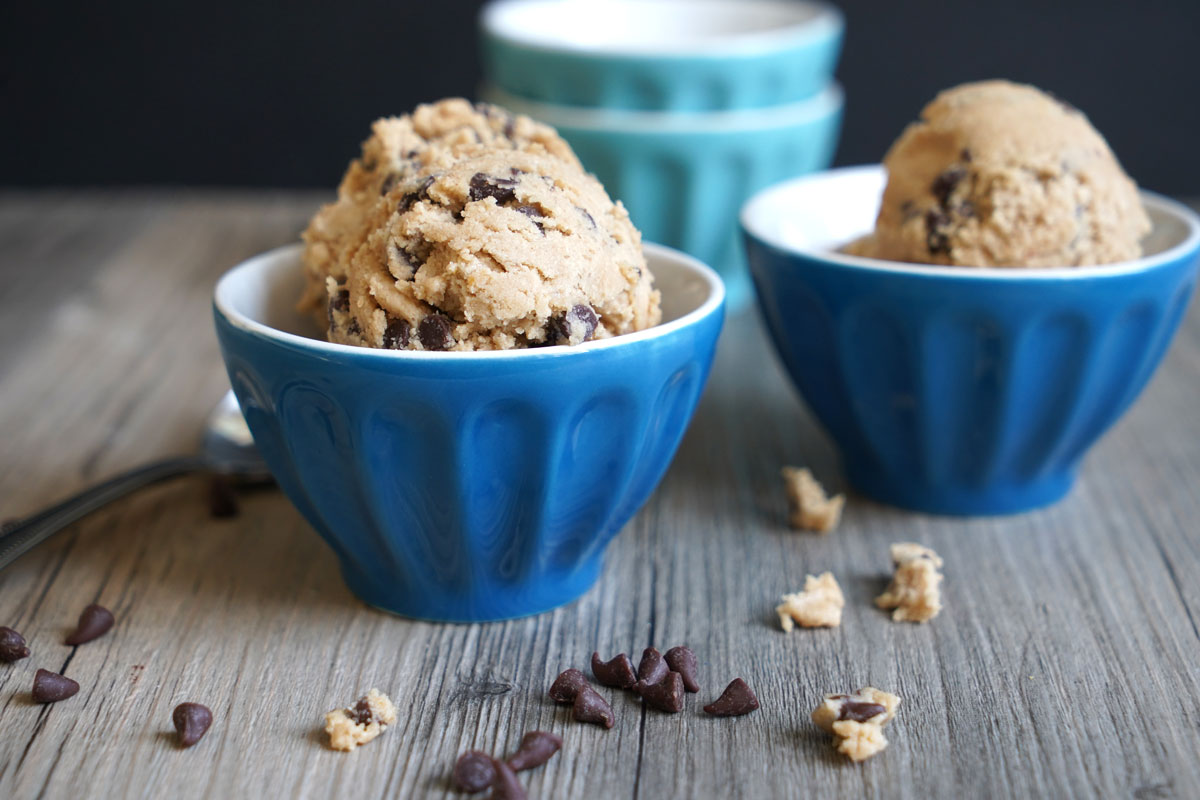 Bowls filled with scoops of edible cookie dough made with oat flour and mini chocolate chips.

