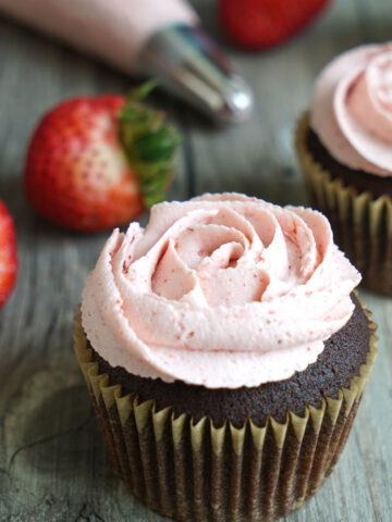Chocolate cupcake with strawberry buttercream piped in a rose design.