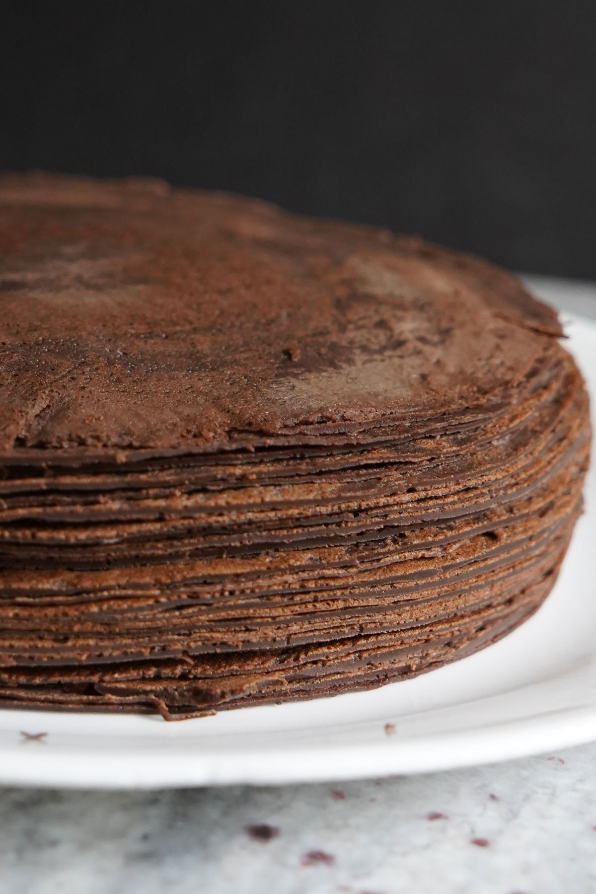 Stack of chocolate crepes on a plate.