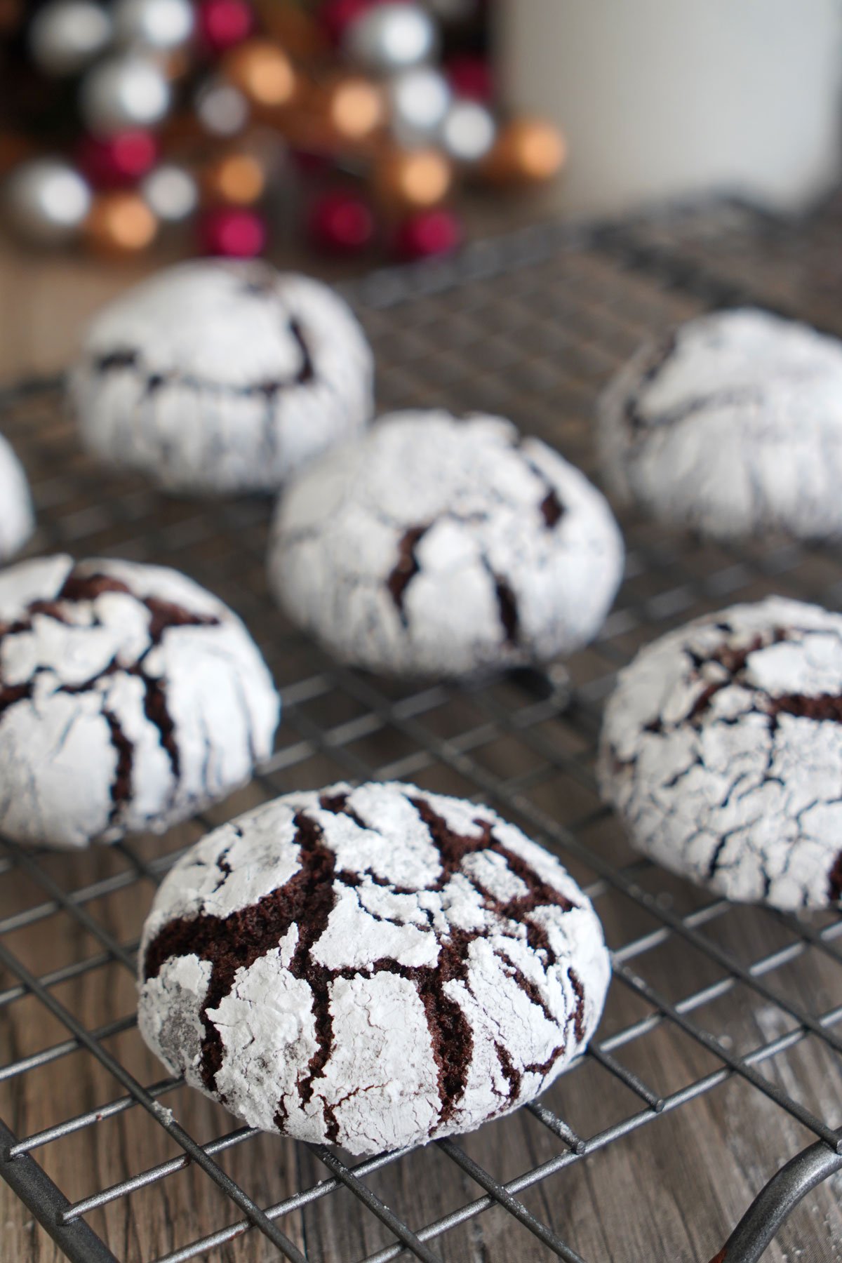 Close up of chocolate crinkle cookie cooling on wire rack.